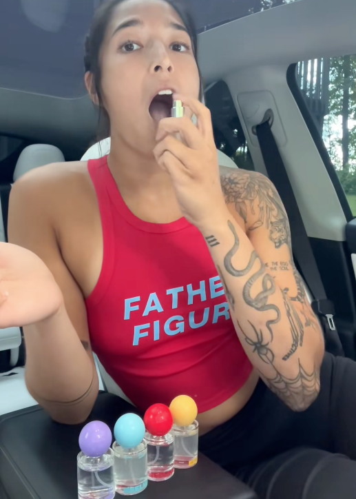 A woman spraying freshn into her mouth with all 5 flavours.